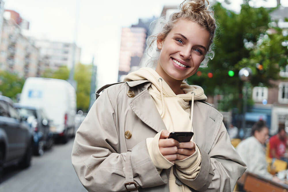 Vrouw loopt met-telefoon op straat