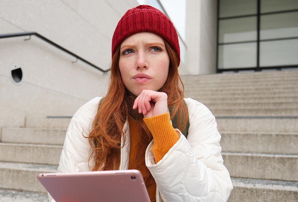 Vrouw denkt vragend na met ipad in haar hand